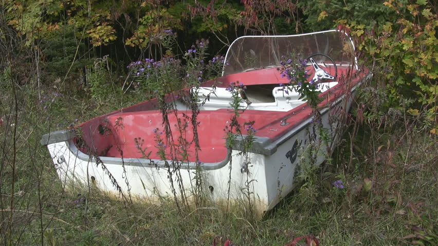 Abandoned red boat. Medium shot.