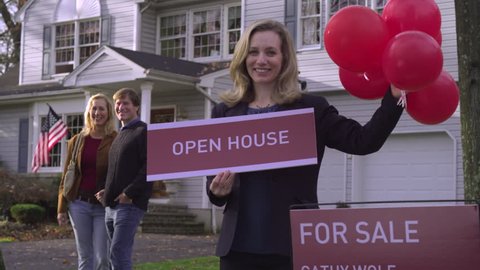 MS, TD, real estate agent holding balloons and a sign saying OPEN HOUSE