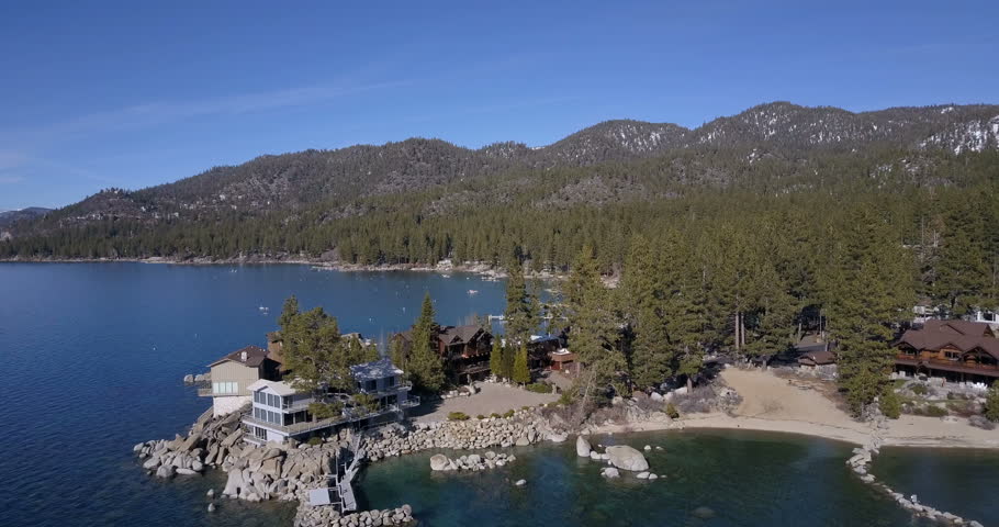 Flying over the Lake Tahoe, flying along the shore with private houses, springtime