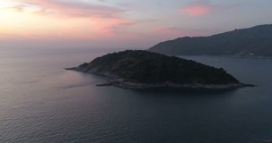 Aerial video of sea with boats and small island off the coast of Thailand during sunset