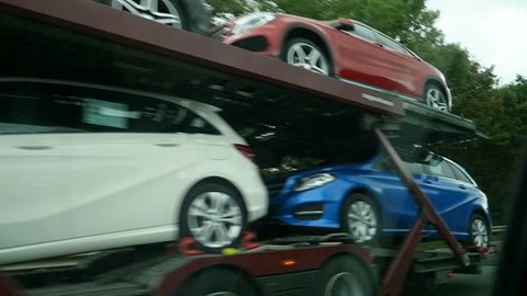 BRUSSELS, BELGIUM - CIRCA 2016: Large truck carrying new Mercedes-Benz cars on Brussels highway autobahn on a rainy day - vehicle logistics, vehicle retailer, transport fleets, fleet transportation
