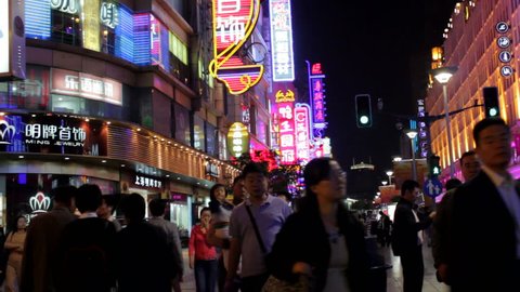 SHANGHAI, CHINA - 15 December 2012: Shoppers and Tourists walk down Nanjing Road, an upmarket Shopping Area at Night. Shanghai, China - 15 December 2012. 