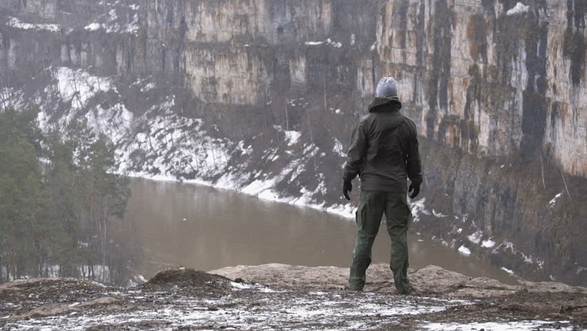 The tourist climbed to the top of a huge rock