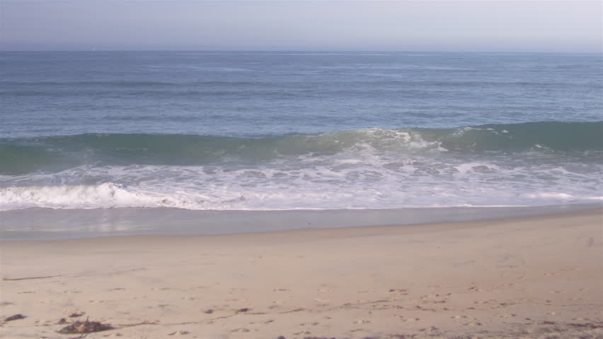 Panning shot of the ocean waves crashing on a beach shore | Shutterstock HD Video #26504924