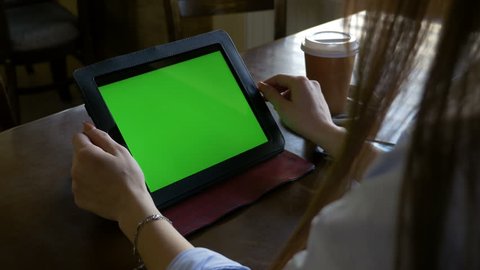 Student at the library reading and studying on a green screen tablet pc and having coffee Video de stock