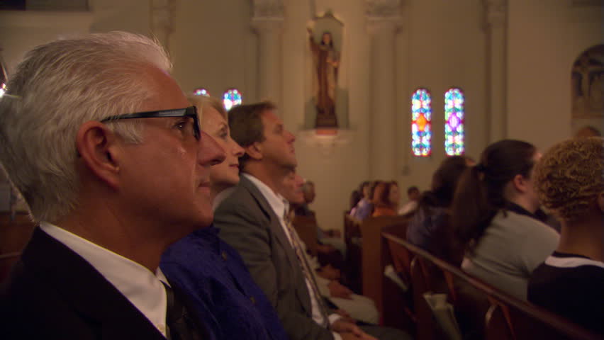 Side view of congregation kneeling in pews and bowing heads Royalty-Free Stock Footage #26509001