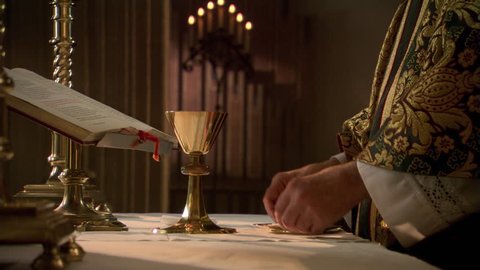 Priest elevating the chalice of wine during Eucharist