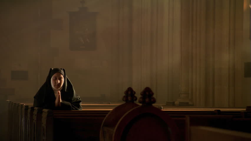 Praying nun kneeling among sun rays in empty church | Shutterstock HD Video #26509220