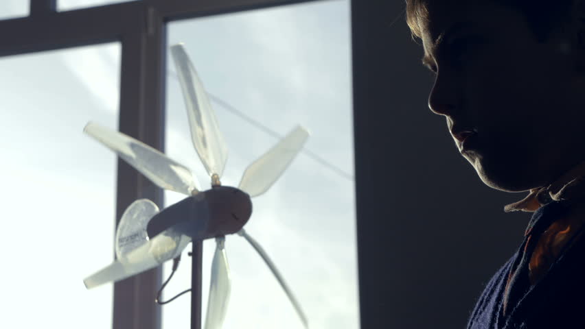 Alternative energy concept. Boy set up wind-driven generator studing alternative enrgy.
