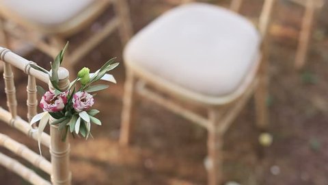 Chairs at a wedding ceremony. Decorated with flower arrangements. Place for a wedding ceremony.