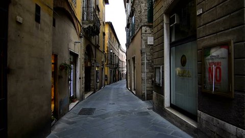 Todi, November 2016: Narrow old italien street with many shops on each side, dolly shot. Historic old town of Todi. Todi is a more than 2000 year old city in Umbria.