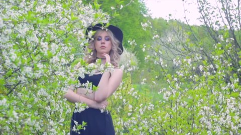 the girl in the black hat in the spring in nature