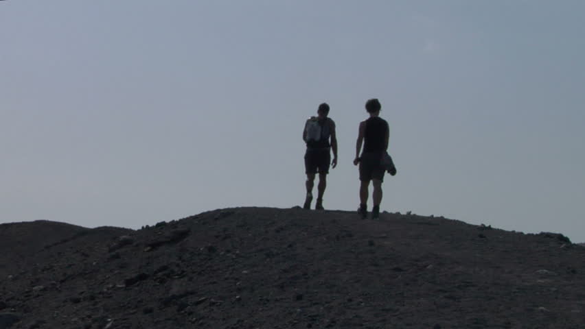Tourists walking on an edge of volcano crater
