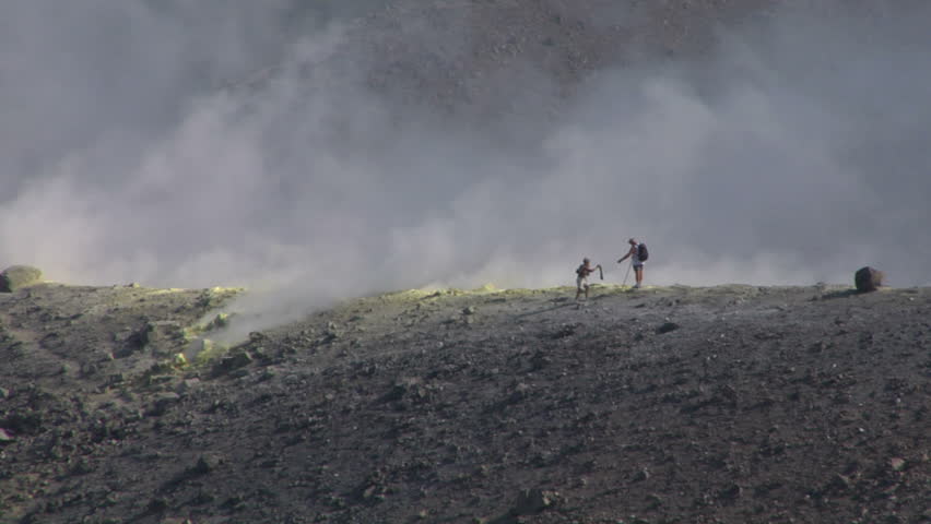 Tourists walking on an edge of volcano crater
