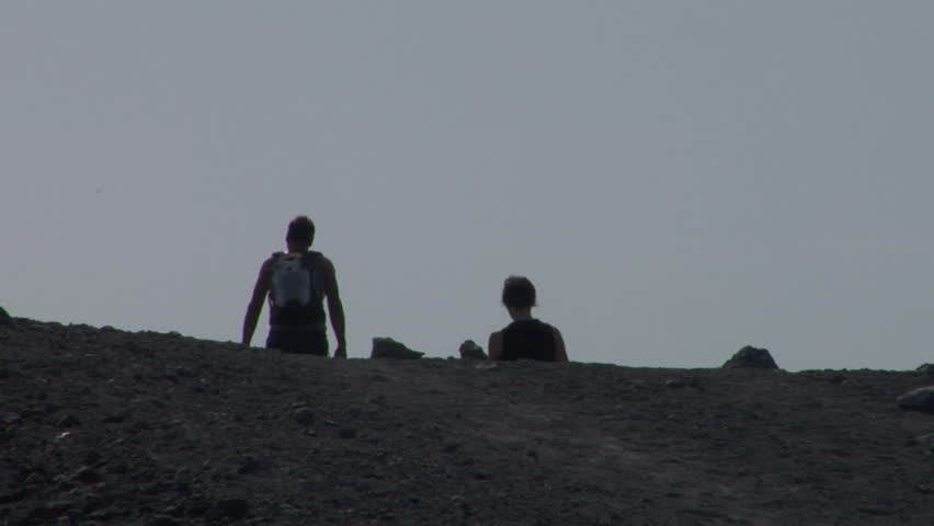 Tourists walking on an edge of volcano crater
