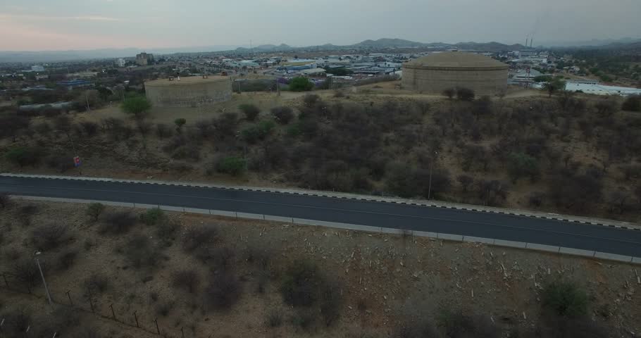 Aerial drone video with view of water reservoirs near highway of B1 main road around Windhoek with view towards industrial area in central highland Khomas Hochland of Namibia, southern Africa