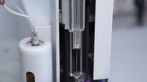 A white chromatographic column operates in the scientific laboratory. In a precise instrument, the device separates the mixture of substances by chromatography. The main constructive element of