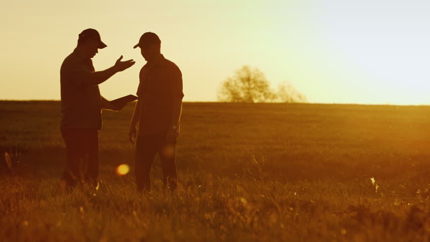 Two businessman farmers shake hands with each other firmly. They talk on the field against a beautiful sunset, they use a tablet. Deal | Shutterstock HD Video #26533409