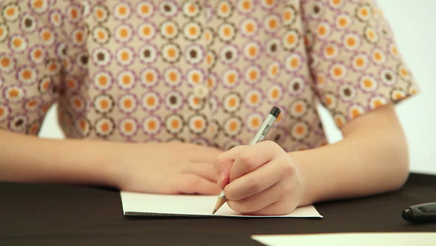 Little boy sits at the desk and does his homework