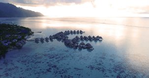Aerial video of Tropical vacation paradise island with overwater bungalows in coral reef lagoon ocean by beach. Aerial video of Moorea, French Polynesia, Tahiti, South Pacific Ocean.