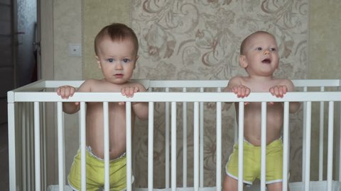 Two cute little brothers jump in one cot