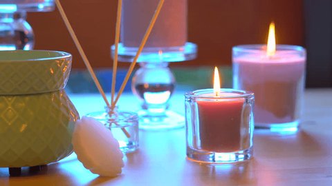 Aromatherapy table setting with perfumed candles, oil burner and mood reeds in natural window light, dolly slider reveal, shallow DOF. Stock-video