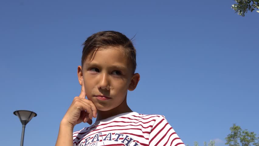 a boy thinks of an idea and smiles