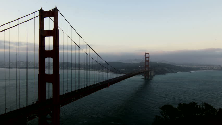 Time-lapse of ships passing under the Golden Gate Bridge at sunrise.