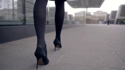 Female legs in black shoes on high heel