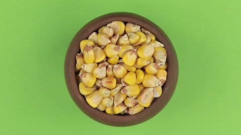 Rotation of the grain of maize in a pot isolated on green screen.