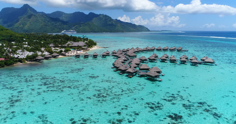 Tropical vacation paradise island with overwater bungalows resort in coral reef lagoon ocean by beach. Aerial video of Moorea, French Polynesia, Tahiti, South Pacific Ocean. Royalty-Free Stock Footage #26557418