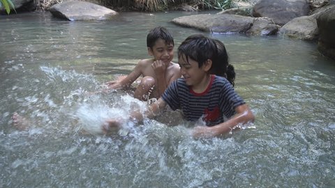 Asian family playing together in the waterfall countryside