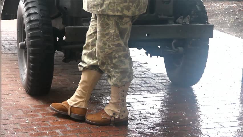 Soldier In Old Style Uniform And Leggings In Front Of Old Style Military Truck In The Rain