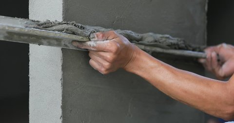 Non identify Construction workers plastering brick wall using cement at construction site
