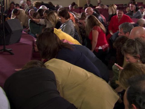 Congregation kneeling in fervent prayer