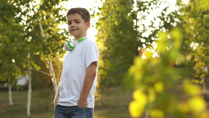 Portrait of a boy outdoors. Schoolboy dressed in jeans and white t-shirt.