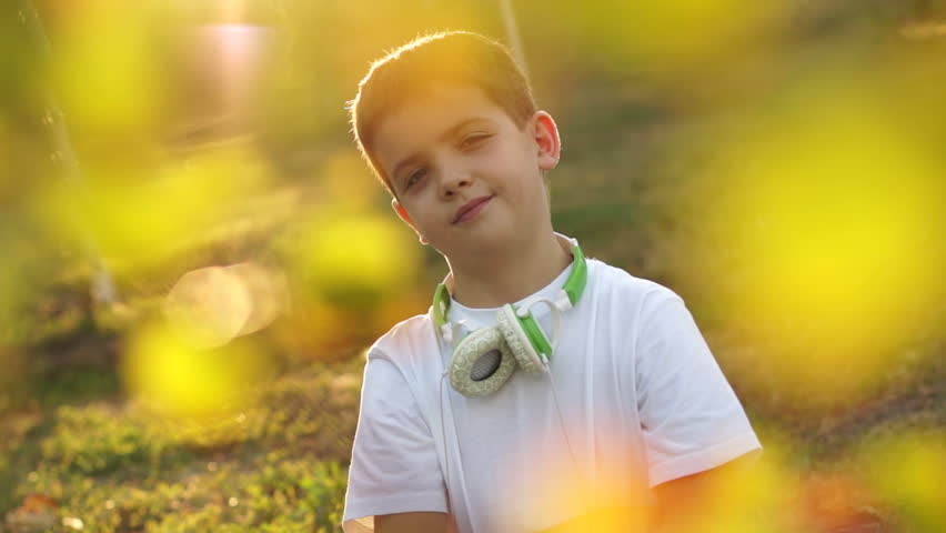 Portrait smiling of a boy outdoors. Teenager dressed in jeans and white t-shirt.