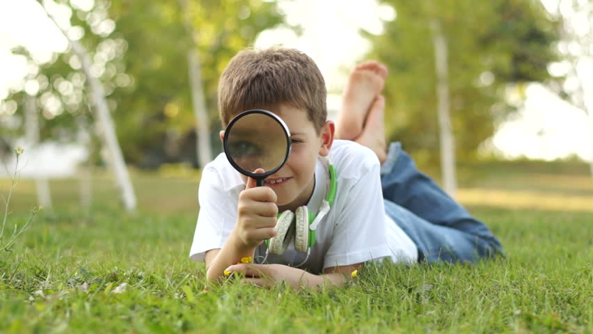 Boy looking through magnifier at camera