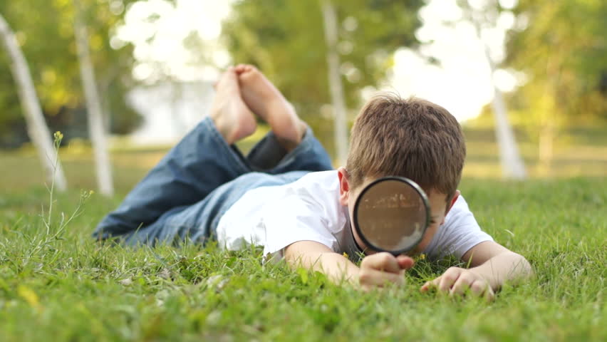 Boy playing with magnifier