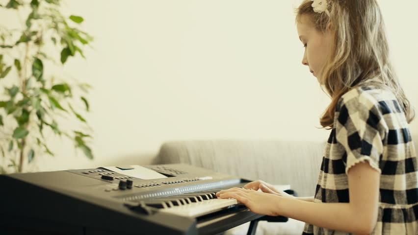 Little girl learning to play the piano. Royalty-Free Stock Footage #26592992
