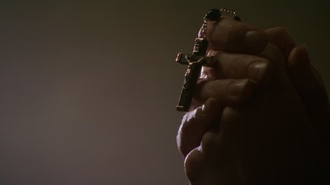 Close-up of woman's hands holding rosary