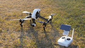 Drone and controller stands on grass