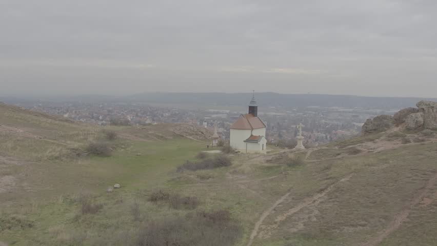 Aerial view of catholic memorial, chapel, cross on top of mountain in Budaors, Hungary. 
RAW footage for creators to color grade and control the look of your project (dlog, d log).