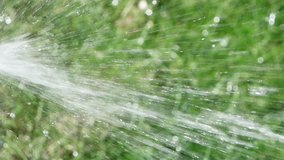 Video 1920x1080 - Defocused abstract water splashing changing direction from lawn sprinkler over the defocused grass - Buy Stock Footage