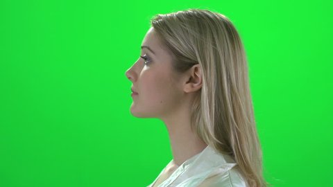 profile view of attractive blond young caucasian women with long hair. one female head close up isolated against green screen background