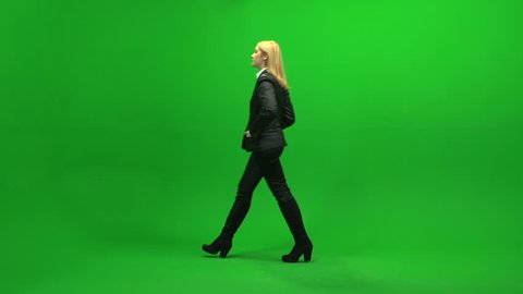 beautiful female sales professional walking into room standing against green screen background. one person isolated