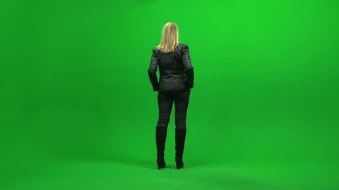full body shot of young women standing isolated against green screen background. one person looking arround in room. female model scene