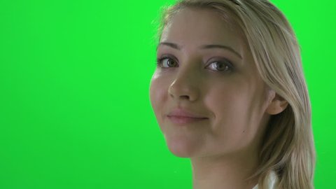 side profile view of young attractive blond women smiling into camera. beautiful female isolated against green screen background
