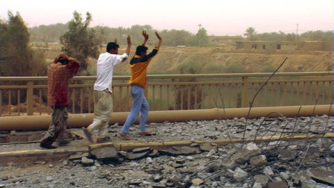 Iraqi citizens fleeing across partially destroyed bridge