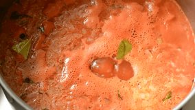 Stirring tomato soup with a spoon.Top view. Close up. Still shot. 60fps.